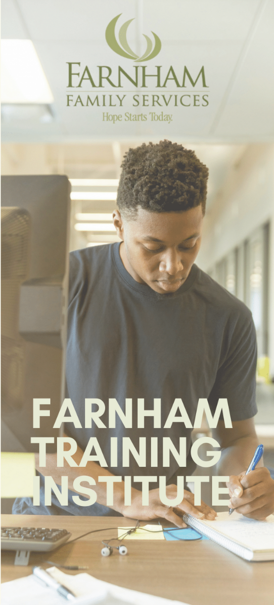 Front of Training Institute Brochure with a man writing while sitting at a desk with a computer